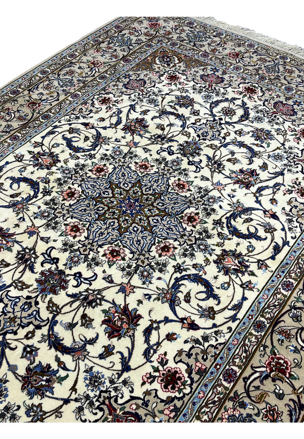 Angled field view of the signed Davari Persian Isfahan rug showing ivory background, navy vines, and detailed floral motifs in pink, blue, and burgundy.