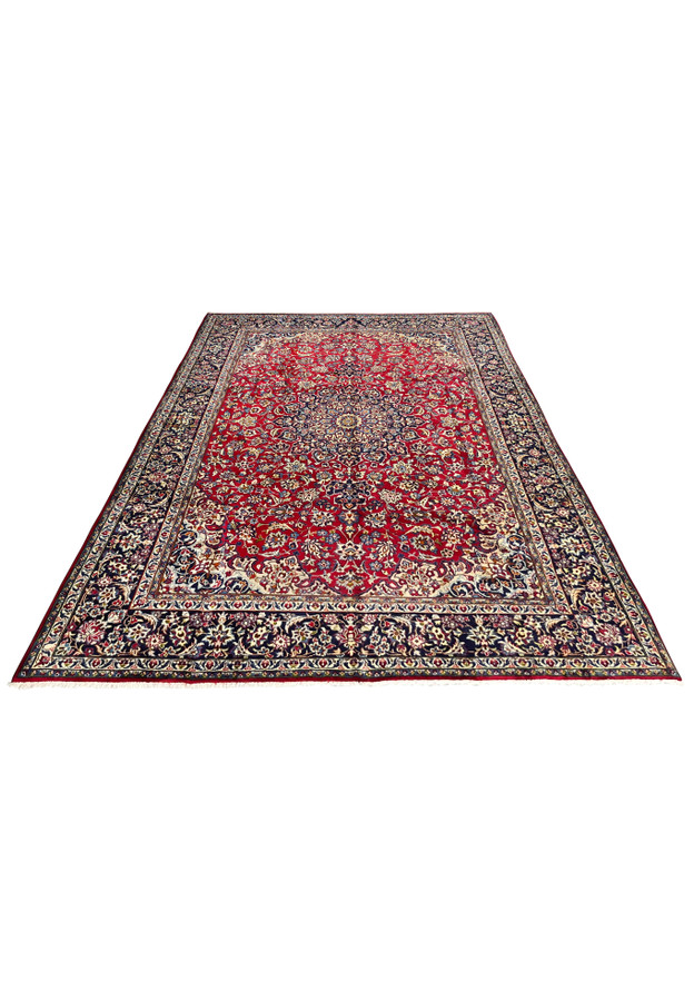 Angled close-up of Persian Isfahan rug medallion and surrounding floral patterns on ruby red field