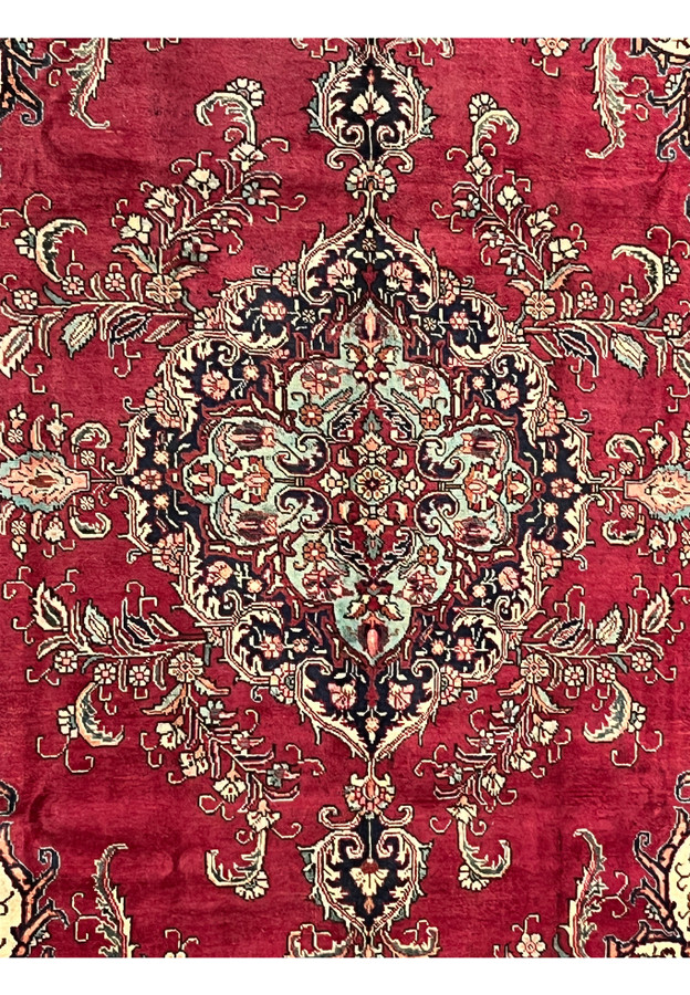 Detailed shot of the central medallion on the Patina Persian Tabriz Rug with teal, navy, and red floral motifs.
