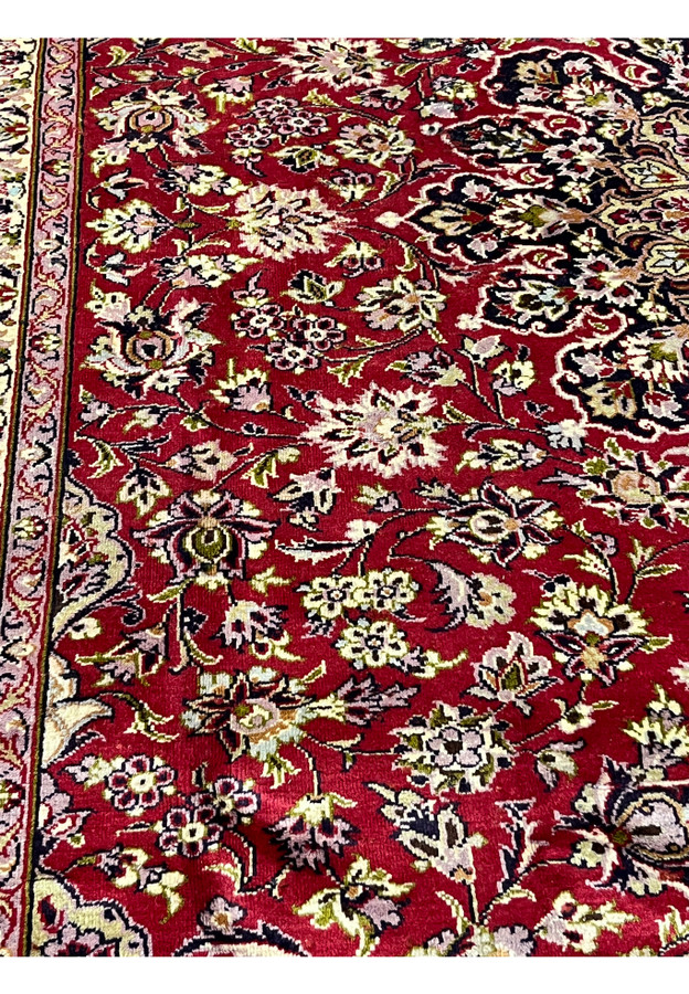 Color closeup of red field Persian Isfahan rug showing detailed floral weaving