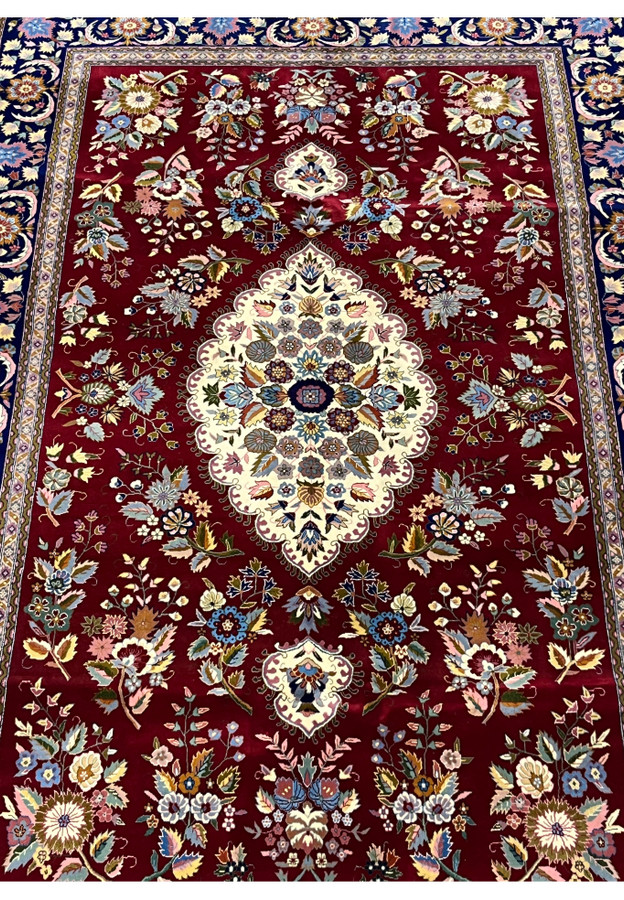 Midfield detail of Persian Isfahan rug highlighting ivory medallion and silk floral accents