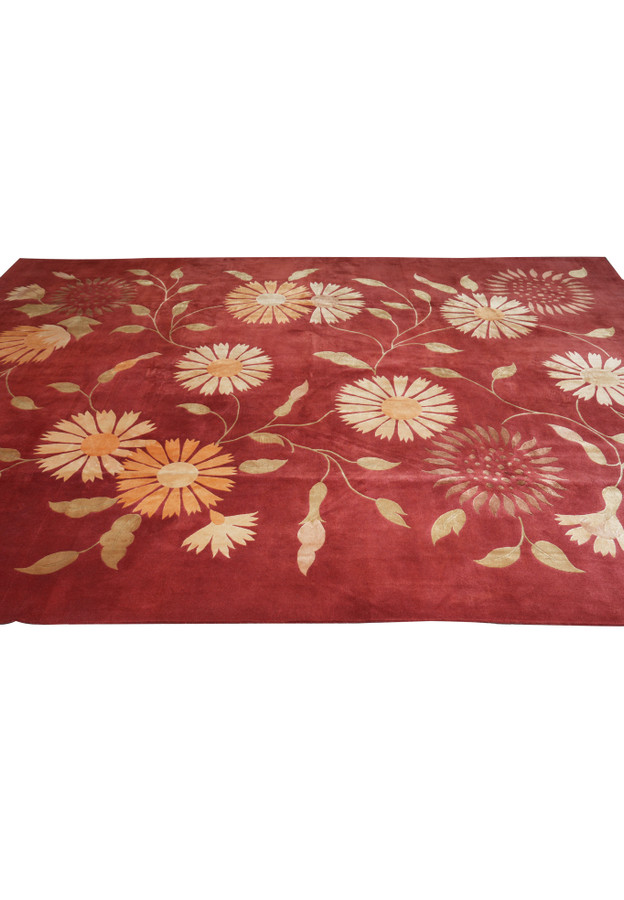 Midfield pattern view of a modern Tibetan wool and silk rug displaying flowing floral vines and balanced spacing across the rich red background