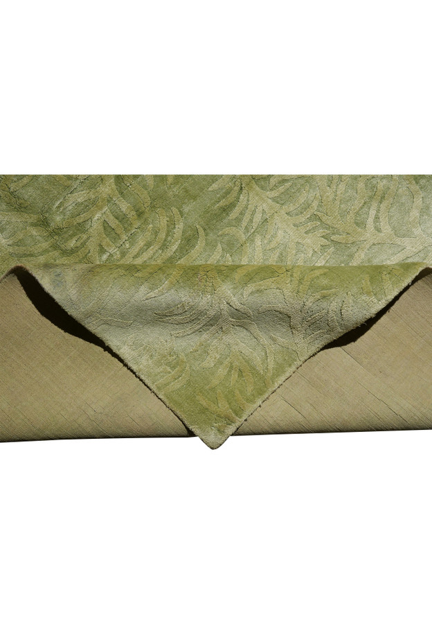 Folded edge view revealing pile height, softness, and the flexible wool and silk construction of the rug.