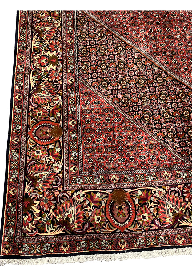Close-up of floral and geometric border motifs in a traditional Persian Bijar iron rug
