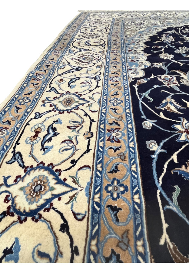 Side border close-up of a 6'5 x 10 Persian Nain 6 LA rug displaying layered ivory borders, light blue vines, and silk-defined floral outlines