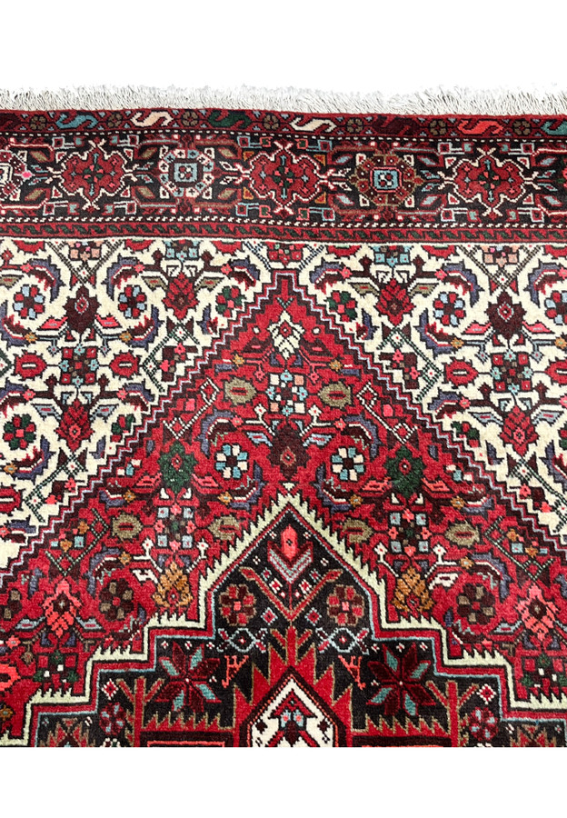 Upper border close-up of a Persian Gholtogh rug featuring geometric tribal motifs, ivory detailing, navy outlines, and crisp hand-knotted definition