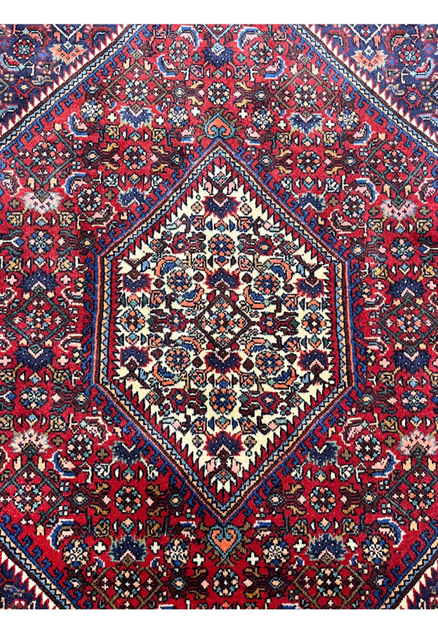 Close-up of ivory central medallion on a Persian Gholtogh rug, highlighting geometric floral motifs, crisp outlines, and saturated wool colors.