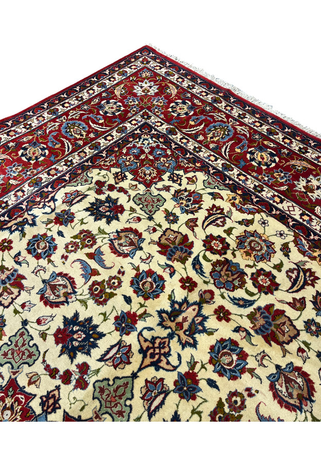 Inner border detail of an Isfahan rug showing layered floral bands, ivory and navy contrast, and fine kork wool craftsmanship with silk detailing.
