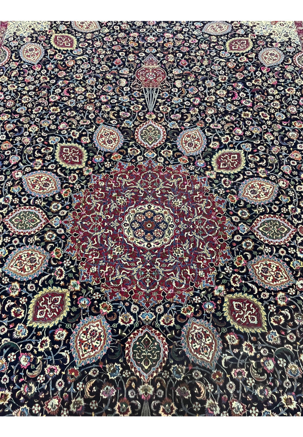 Close view of central medallion on Persian Mashad rug signed Sheshkalani, displaying detailed floral geometry, silk accents, and rich red and navy color contrast.
