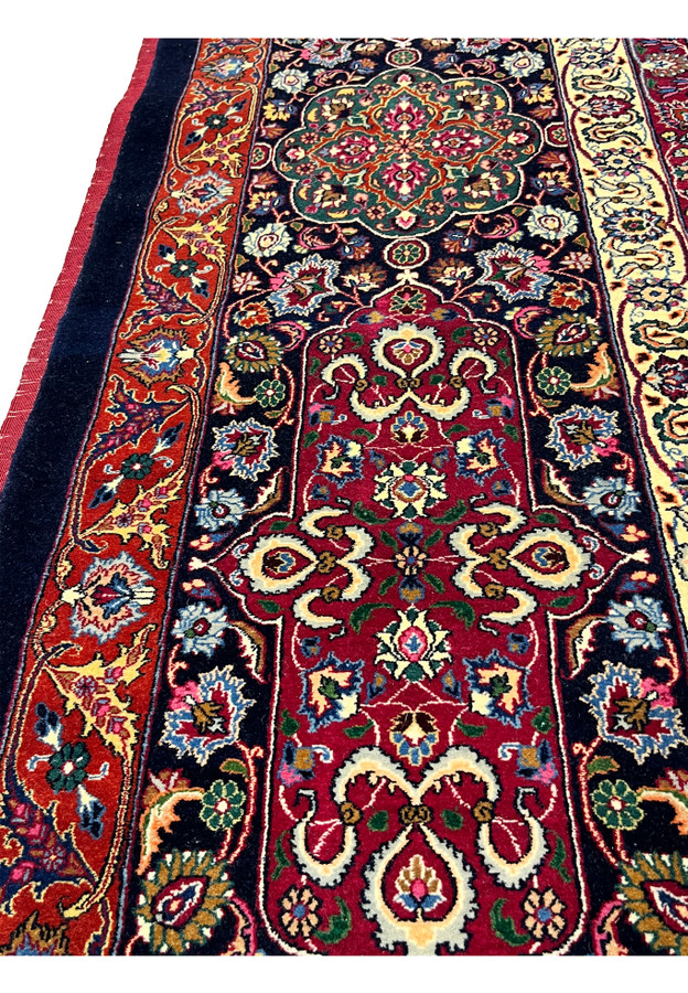 Border close-up of Persian Mashad rug with layered floral bands, precise knotting, silk accents, and classic red, navy, and ivory color harmony