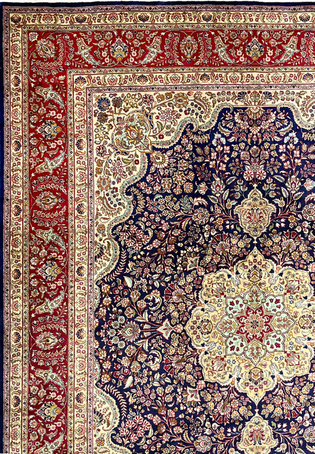 Classic ivory border of Persian Tabriz rug with repeating floral motifs, clean symmetry, and strong contrast against navy ground