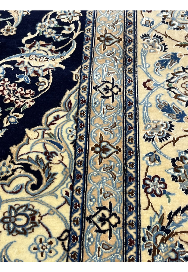 Pattern close-up of a Persian Nain 6 La rug highlighting fine floral vines woven in silk and kork wool on ivory ground