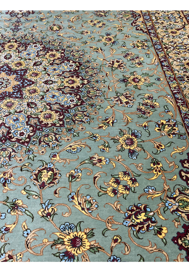 Field detail of a Mirmehdi signed Persian Qum silk rug revealing sage green silk ground, subtle turquoise undertones, and refined drawing