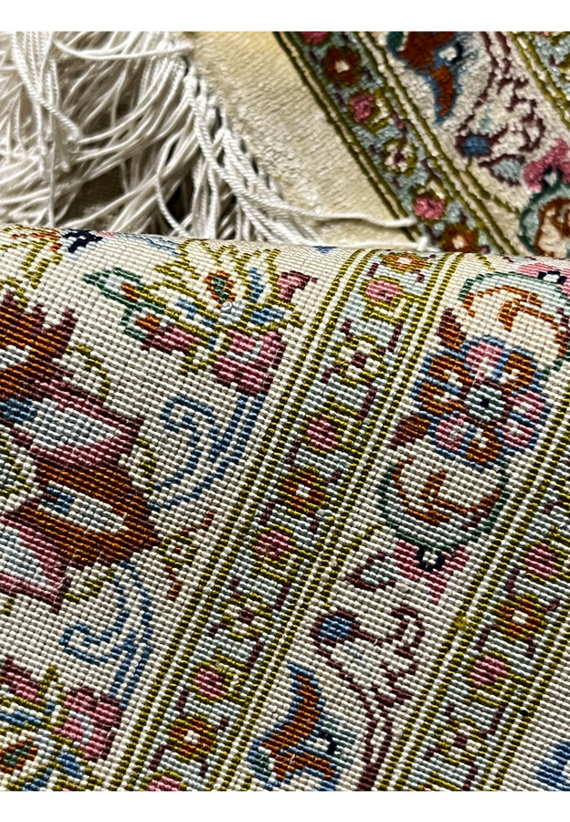 Backside view of a signed Persian Qum silk rug showing extremely fine knot density, clean structure, and uniform hand-knotted silk foundation.
