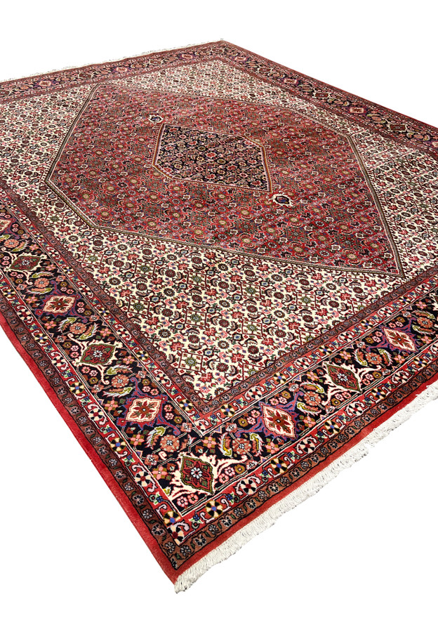Angled perspective of 8x10 Persian Bijar rug emphasizing heavy structure, dense weave, bold medallion geometry, and rich color contrast