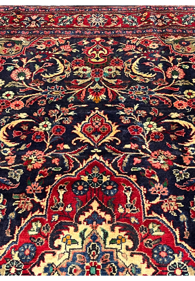 Upper section Persian Mahal rug with floral vines corner spandrels navy field and layered red borders