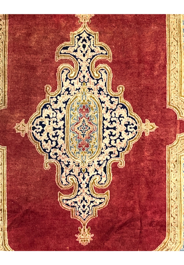 Zoomed medallion closeup antique Kerman rug fine knots ivory navy arabesque floral pattern aged wool surface