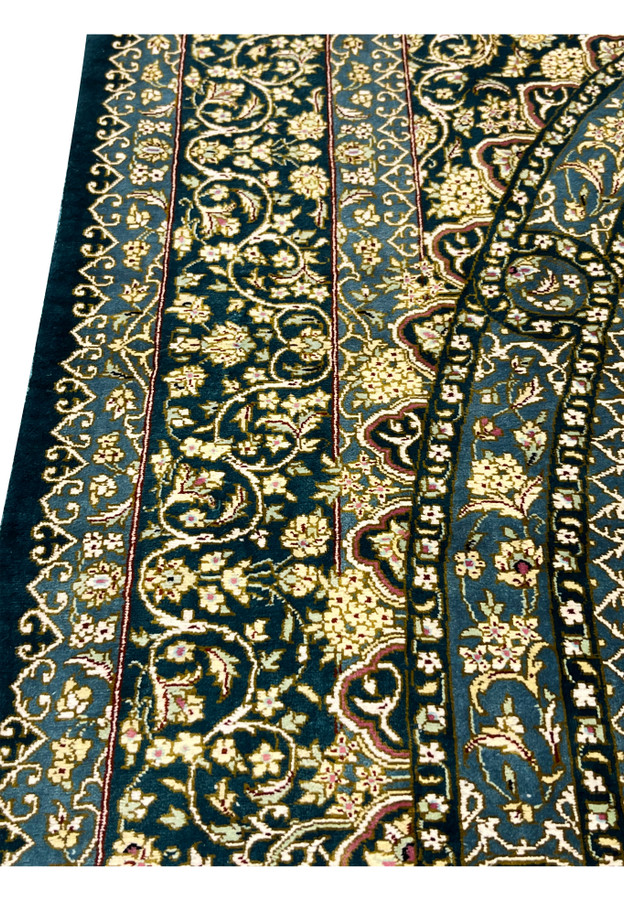 Macro border view showing tight silk knots, scrolling vines and delicate blossoms in ivory gold and navy tones