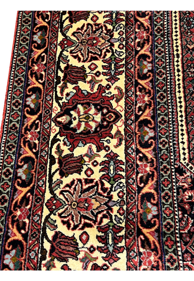 Border close up of 8'2 x 11'4 Persian Bijar Iron Rug with ivory floral elements, red field contrast and heavy hand knotted construction