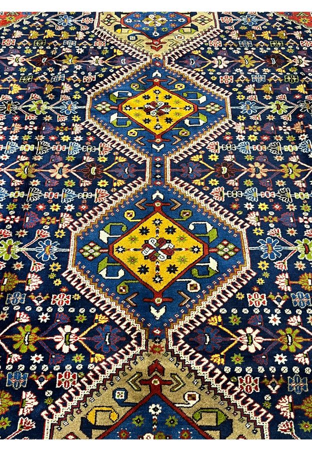 Closeup of triple medallion detail 8'7 x 11'7 Persian Yalameh rug with ivory serrated outlines and yellow center accents