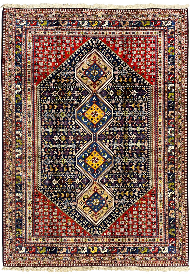 Full view 8'7 x 11'7 Persian Yalameh tribal rug with navy field, brick red corners and bold geometric triple medallion design.