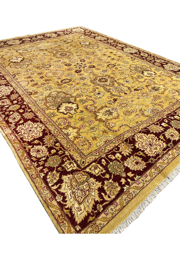 Angled perspective of 9x12 antique gold Agra rug with deep burgundy border and dense floral field