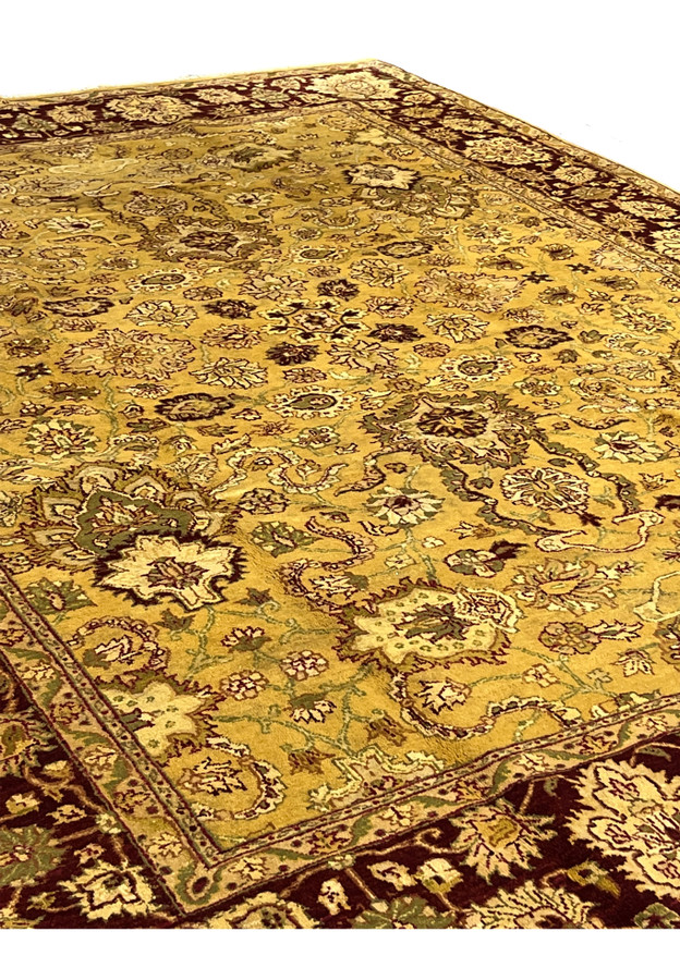 Midfield section of handmade gold Indian Agra rug showing dense floral lattice pattern with wine red and sage green detailing