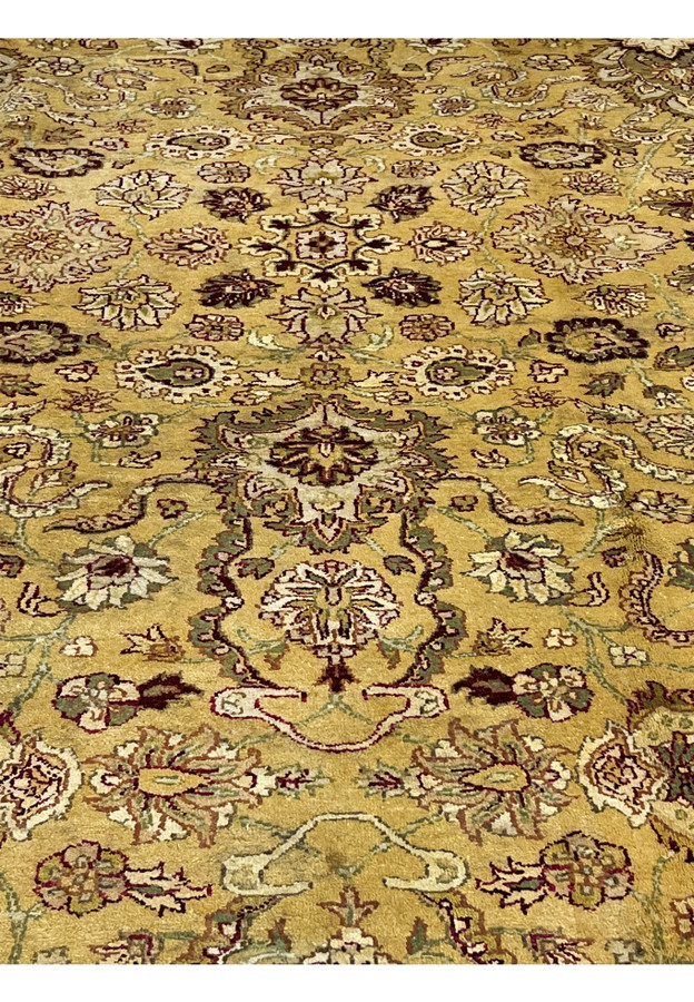 Antique style Indian Agra rug closeup highlighting central floral medallion motifs with ivory accents and deep burgundy outlines.