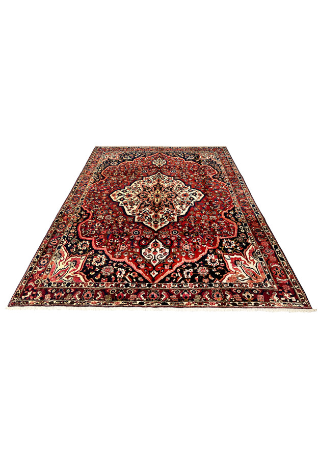 Persian Bakhtiari rug 10'9 x 13'7 laid flat, showing full medallion design in red and navy wool.