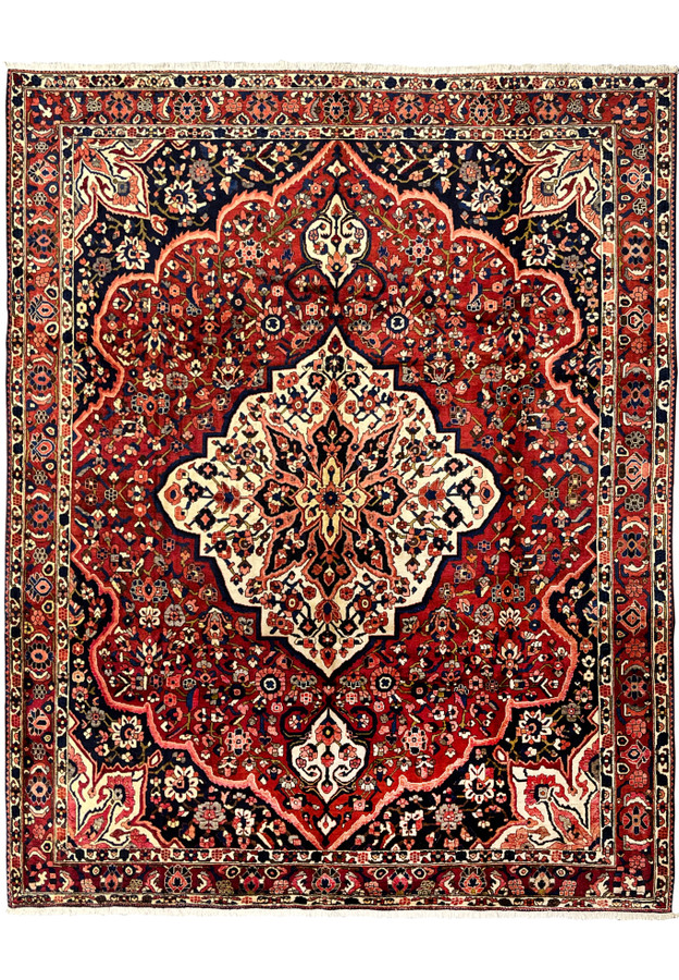 Vintage Persian Bakhtiari rug 10x14 full view, hand-knotted wool with crimson red field and ivory star medallion.