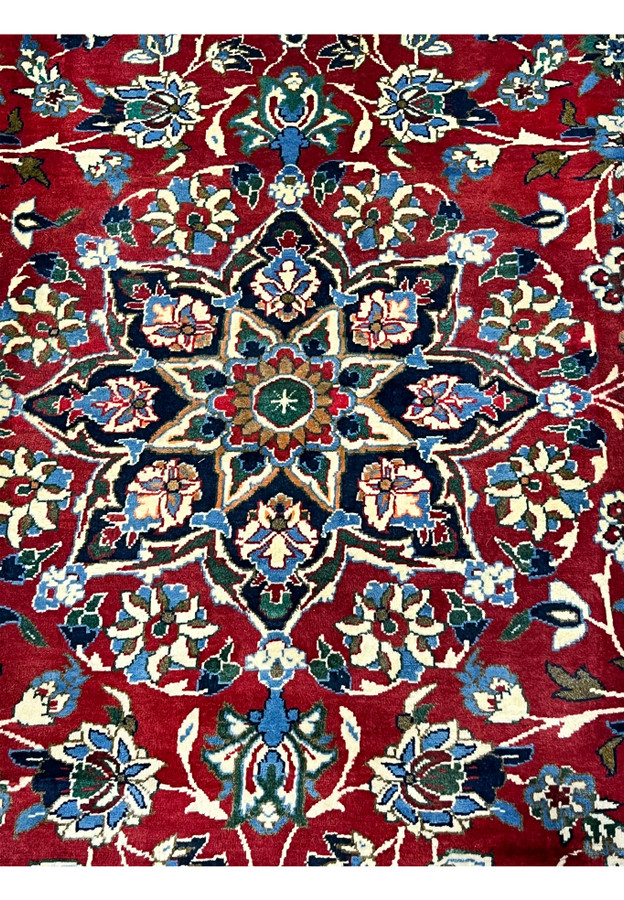 Central medallion closeup 8x12 Persian Isfahan wool rug navy star medallion on crimson red field ivory blue floral