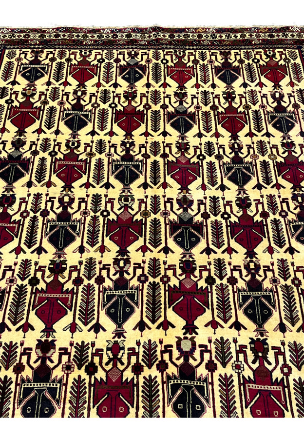 Close-up of tribal boteh motifs in 5x8 Persian Afshar wool rug on warm ivory ground