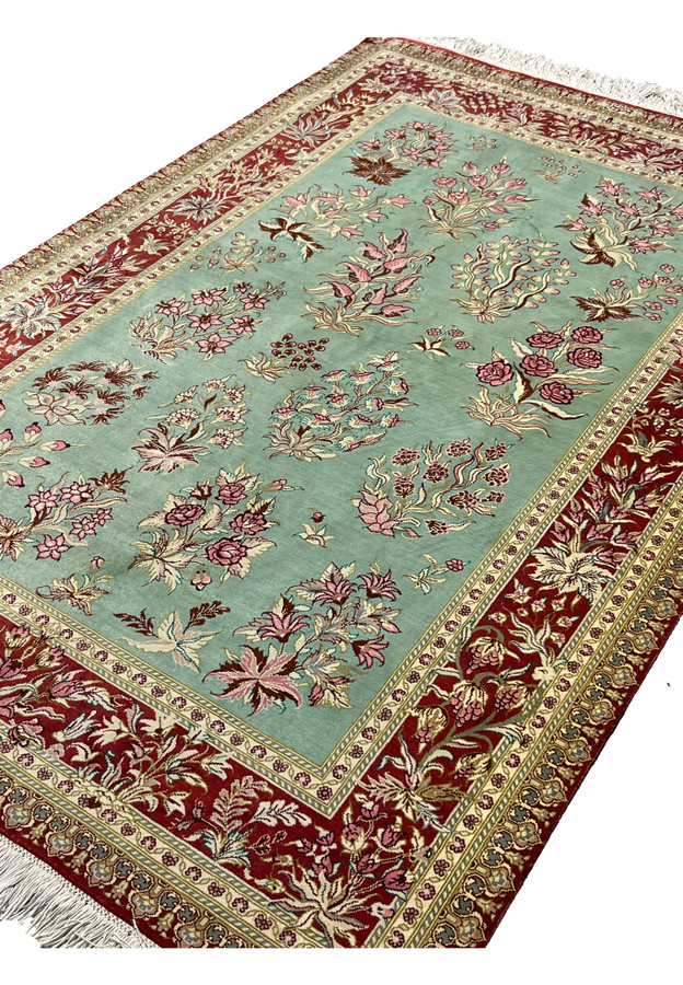 3x5 Persian Qum pure silk rug signed Motevasel garden floral celadon green crimson red angled view