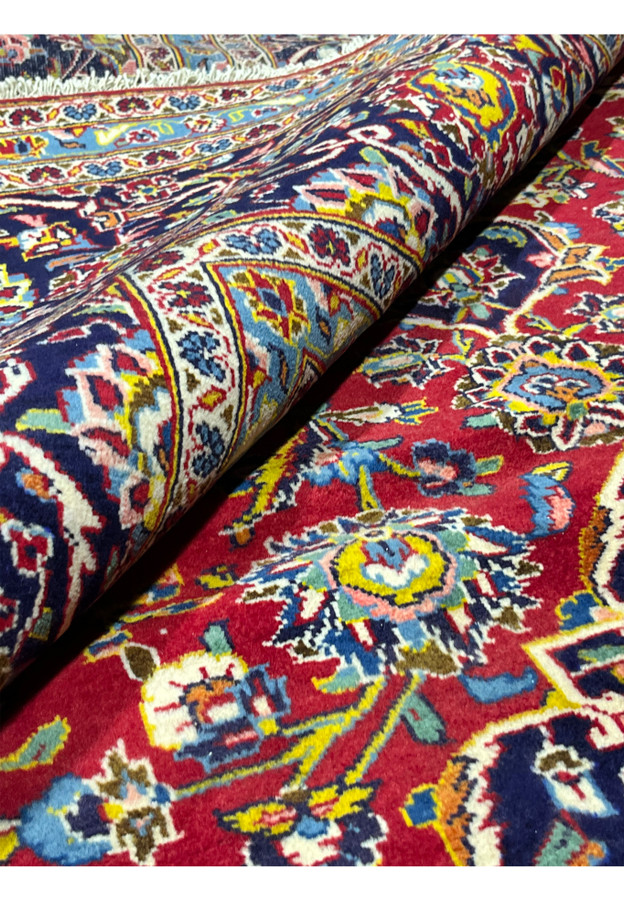 10x14'7 Persian Kashan rug featured on Shark Tank rolled view wool pile crimson navy border detail
