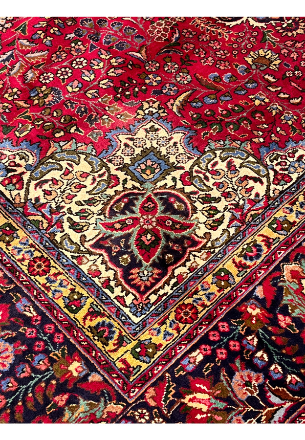 Inner border of 10x13 Persian Tabriz rug showing ivory spandrel meeting gold guard and navy border
