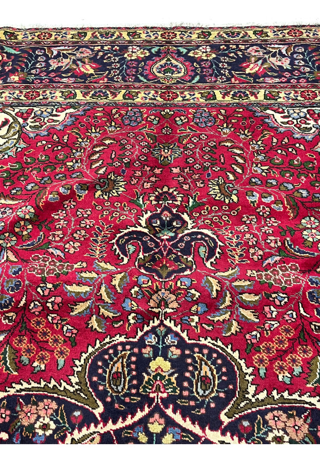 Pattern and motifs closeup on 10x13 Persian Tabriz rug, red field with rosettes and paisley