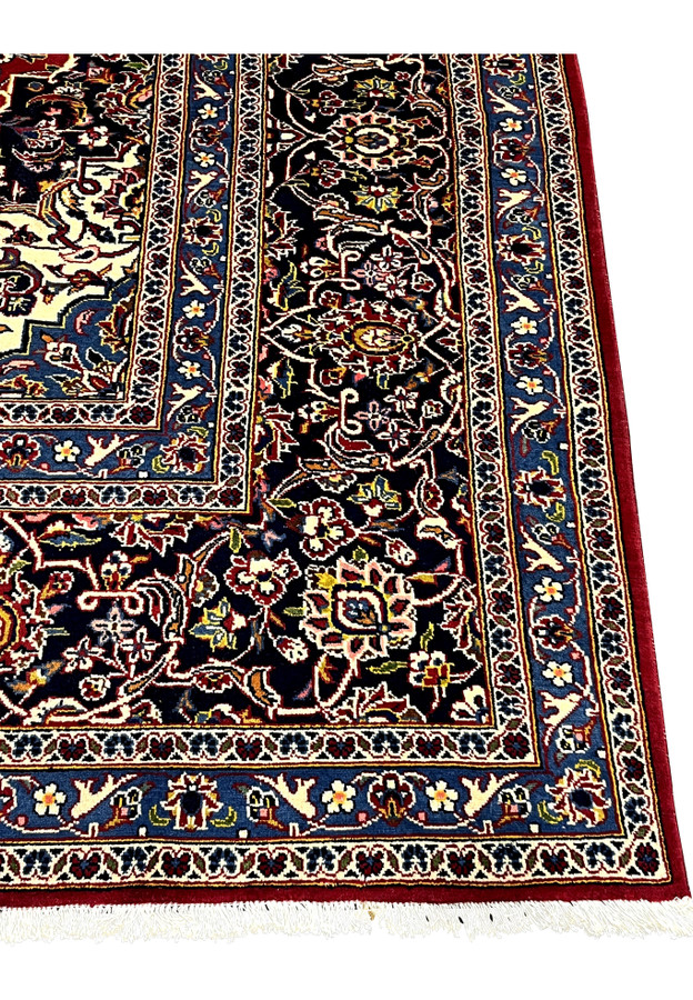Navy main border with layered guard stripes framing the red field of this authentic Persian Kashan rug