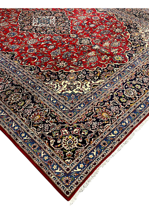 Full-length edge profile of this 10x13 Kashan rug with ivory fringe and layered floral borders