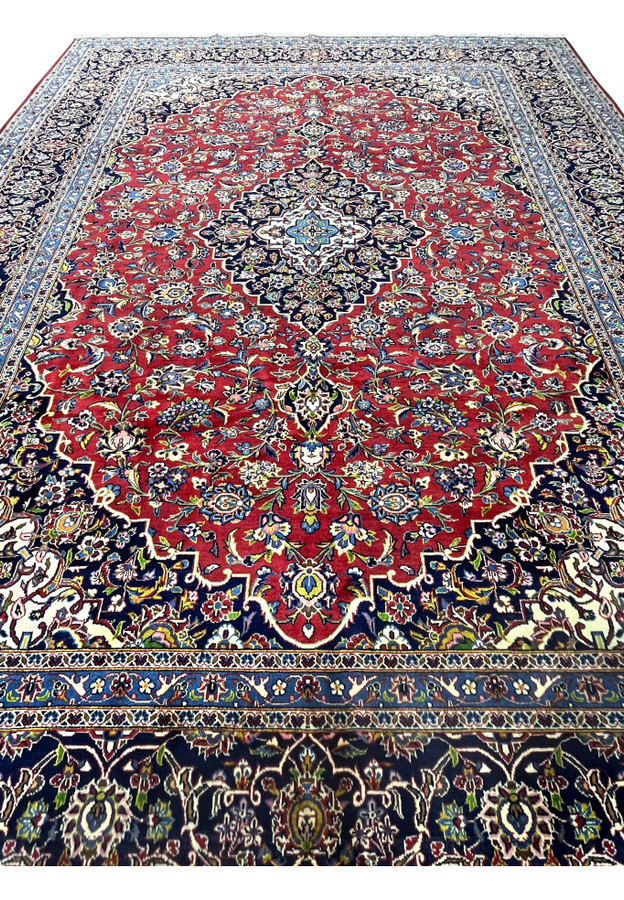Red Kashan field with dense Shah Abbasi floral vocabulary and central navy medallion in hand-knotted wool