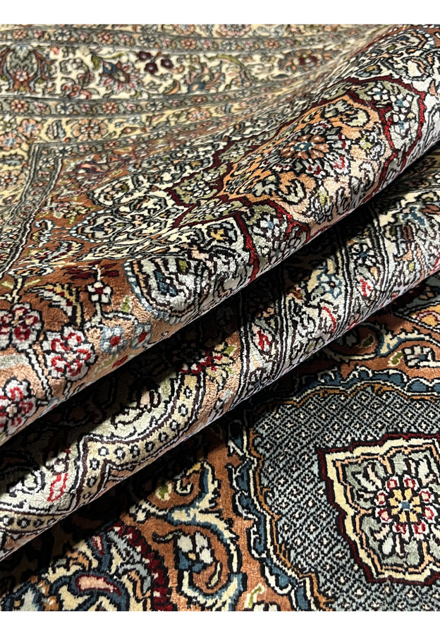 Rolled edge of this Turkish silk rug showing super thin 0.2 inch pile and silvery ivory ground