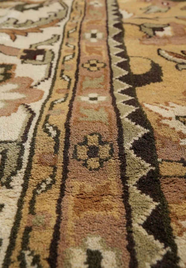 Pattern closeup with stylized palmettes serrated leaves and curling vine in soft camel and sage