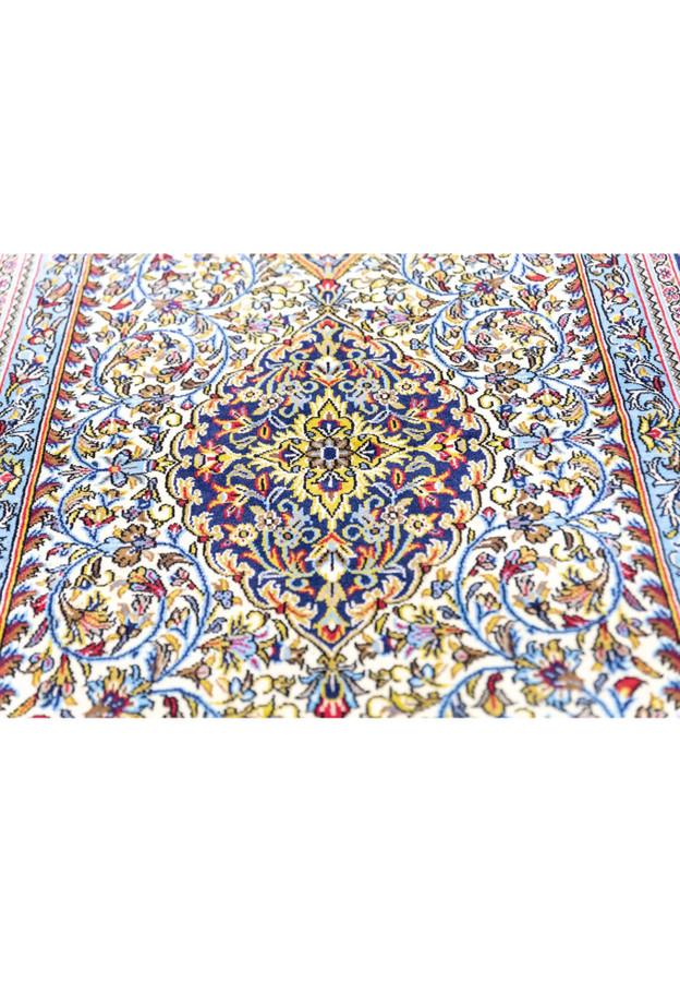 Indigo central medallion close-up with golden palmettes and red rosettes on Persian Qum kork wool rug