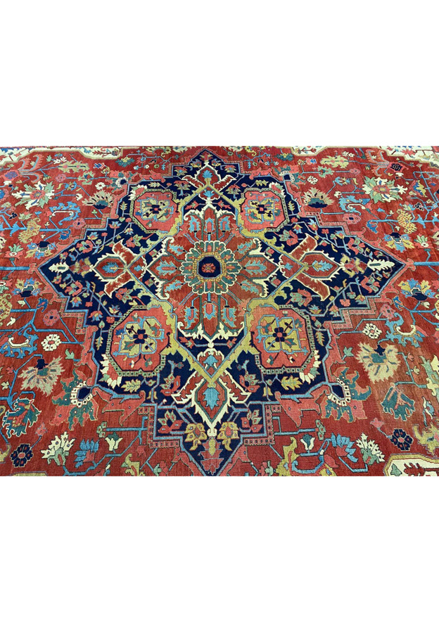 Stepped diamond central medallion in midnight navy with eight-pointed flower head on Serapi Heriz rug