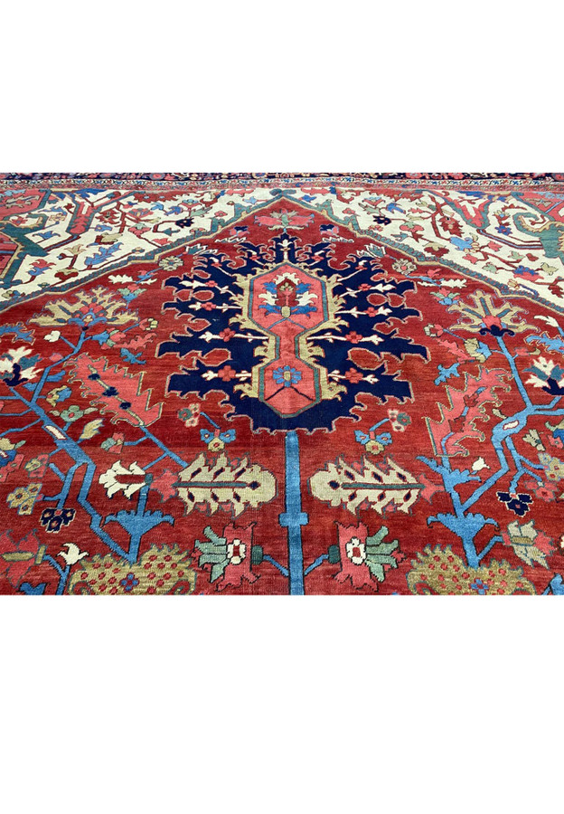 Detailed pattern shot of large palmettes, willow leaves, and scrolling vines on antique Heriz field