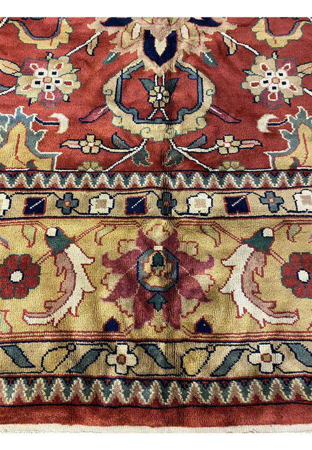 Lower border detail showing palmette-and-vine repeat in gold and navy on Indo Agra mansion rug