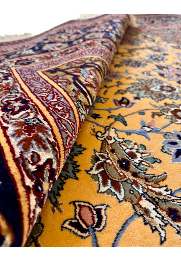 Rolled view of Haghighi Isfahan rug showing thin pile, fine knot density, and silk highlight luminosity