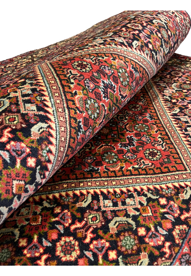 Rolled view of the Persian Bijar showing the legendary heavy iron rug body and tight wool pile
