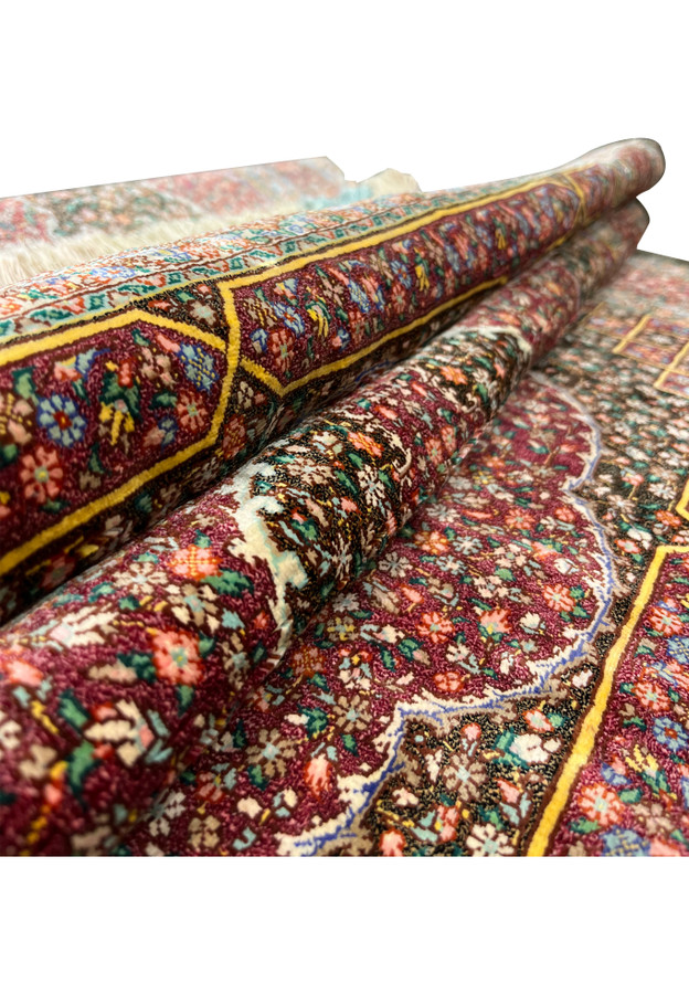 Rolled view of the Qum showing the supple drape and luxurious silk pile of this rug