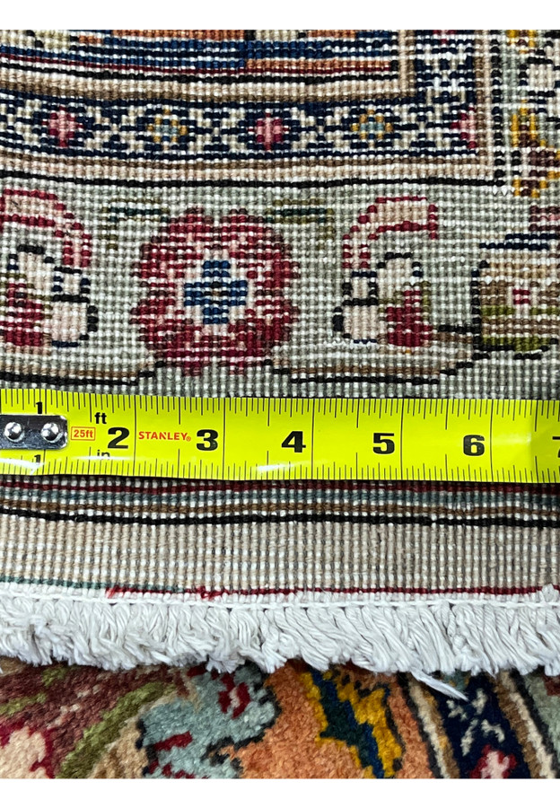 Tape measure across the rug back documenting the knot density and confirming the fine quality Tabriz weave