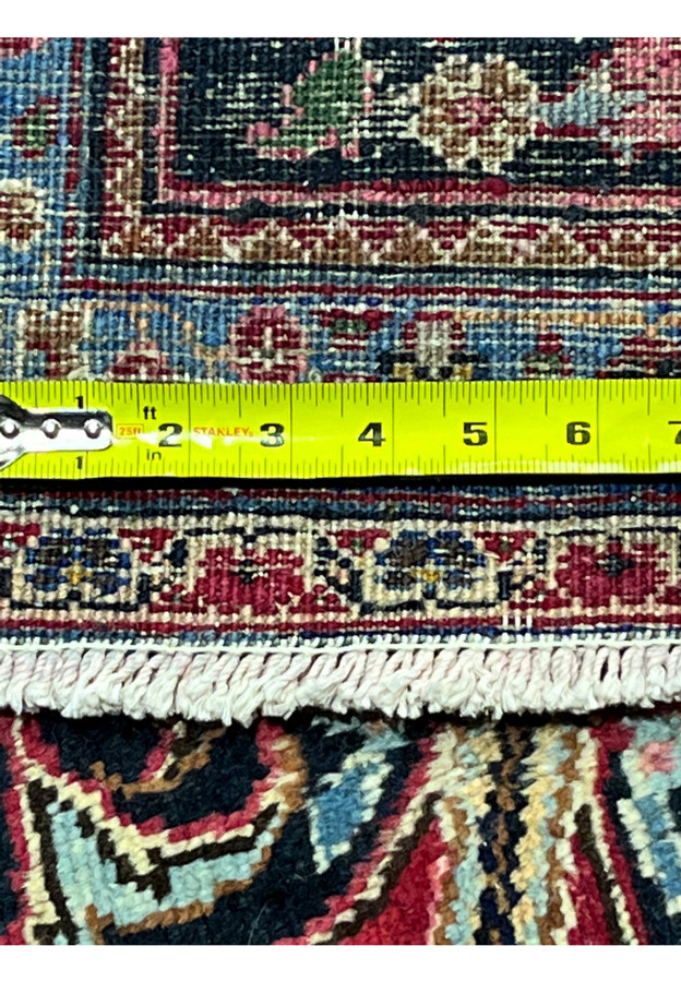 Backside of Persian Kerman rug photographed with measuring tape against the weave for verification of fine knot density